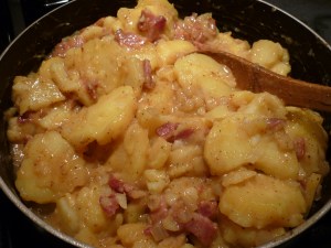 Chop bacon, thinly slice potatoes. Carefully stir into hot mixture. Heat through, stirring lightly to coat potato slices. 