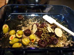 Into a 9x13" baking dish, mix together: 2 Tbsp. dried oregano; Salt and pepper; ¼ cup red-wine vinegar; ¼ cup olive oil; Handful pitted prunes; Handful green olives (mine were jumbo-sized, so I cut them in half); 2 Tbsp. capers with a little juice; 3 bay leaves