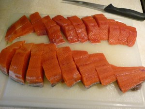 Work with salmon fillets. Cut the fillets across into strips about 1” wide. 