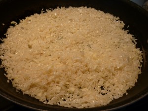 Heat 2 Tbsp. olive oil in large skillet. Stir in 3 cloves garlic, crushed; ½ tsp. dried red pepper flakes; and 2 cups short-grain white rice (I always use Jasmine rice). Cook, stirring, to coat rice with oil, about 3 minutes.  