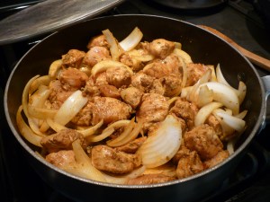 Meanwhile, heat 2 tablespoons olive oil in a separate large skillet over medium heat. Stir in marinated chicken and 1 Spanish onion; cook 5 minutes. 