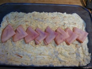 Layer 8 slices Canadian bacon or ham lunchmeat or leftover ham slices along the center of the dish decoratively.