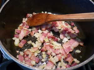 In the same pan, stir 1/8# (3-4 slices) chopped bacon over medium heat until lightly browned, about 5 minutes. Discard fat, if any. Add 1/2 small onion and 1 clove garlic; stir and cook until onion is limp, about 5 minutes. 