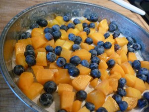 Butter and flour 9-inch cake pan if it is non-stick. If it is not non-stick line the bottom of the pan with parchment paper.   Scatter fruit evenly on the bottom of the pan and set aside. 