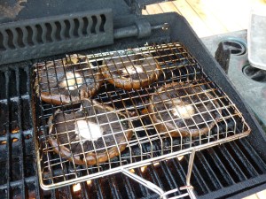 Rachael Ray recommends putting the mushroom caps on the grill and then placing a frying pan on top of them to gently press down. It works surprisingly well and I have done it that way many times. Grill for 3-4 minutes each side. This particular time that I’m showing you, I put the mushroom caps into a grill basket and grilled them that way. It worked great, too. You decide.